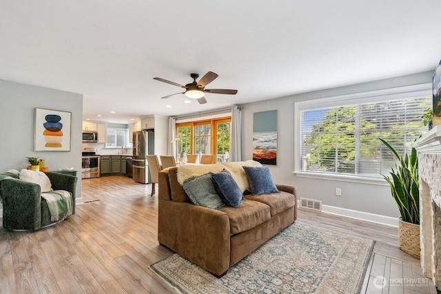 4431 SW Kenyon Pl, Seattle, WA 98136 - living area featuring light wood-type flooring, ceiling fan, recessed lighting, and a fireplace