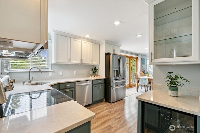 4431 SW Kenyon Pl, Seattle, WA 98136 - kitchen with appliances with stainless steel finishes, plenty of natural light, white cabinetry, recessed lighting, and light wood-style flooring