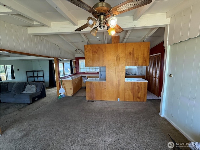 1309 29th St, Anacortes, WA 98221 - kitchen featuring dark carpet, a ceiling fan, brown cabinets, and wood walls