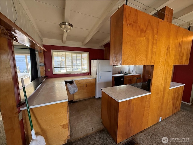 1309 29th St, Anacortes, WA 98221 - kitchen with freestanding refrigerator, black dishwasher, brown cabinetry, light countertops, and beam ceiling
