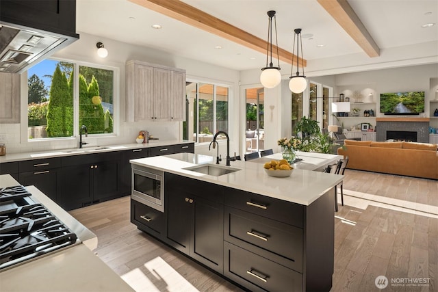 4405 88th Ave SE, Mercer Island, WA 98040 - kitchen with stainless steel microwave, dark cabinets, light countertops, beamed ceiling, and light wood finished floors