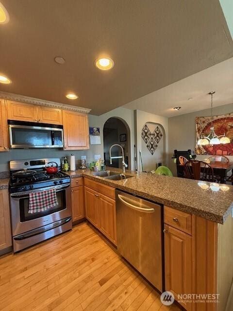 2103 Tacoma Ct, Tacoma, WA 98405 - kitchen with stainless steel appliances, a peninsula, arched walkways, light wood finished floors, and recessed lighting