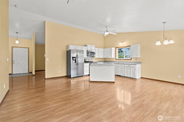 7609 39th Ct SE, Lacey, WA 98503 - kitchen with stainless steel appliances, white cabinets, ceiling fan, light wood-style flooring, and high vaulted ceiling