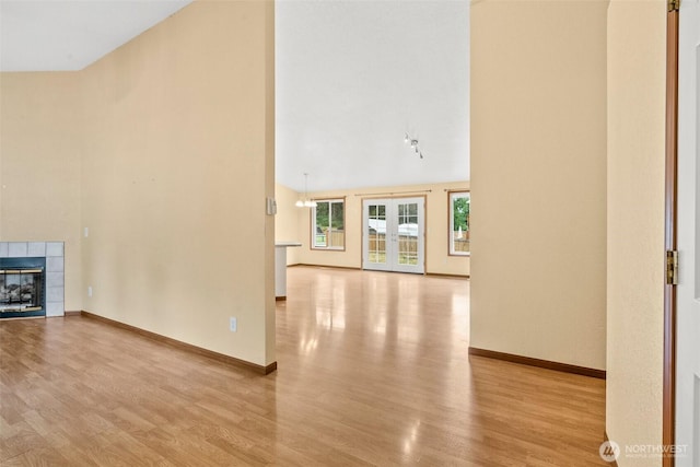 7609 39th Ct SE, Lacey, WA 98503 - unfurnished living room with high vaulted ceiling, wood finished floors, and a tile fireplace