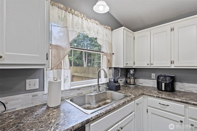 2253 Wellman Pl, Oak Harbor, WA 98277 - kitchen with decorative backsplash, white cabinetry, and vaulted ceiling