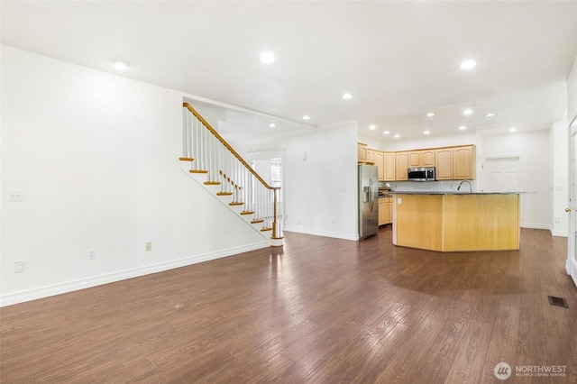5476 Lorri Ln, Moses Lake, WA 98837 - kitchen featuring stainless steel appliances, open floor plan, light brown cabinets, dark countertops, and dark wood-style floors