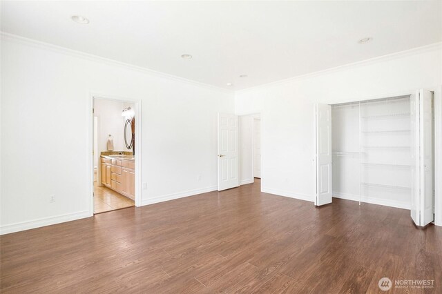 5476 Lorri Ln, Moses Lake, WA 98837 - unfurnished bedroom featuring crown molding, dark wood-style floors, a closet, and connected bathroom