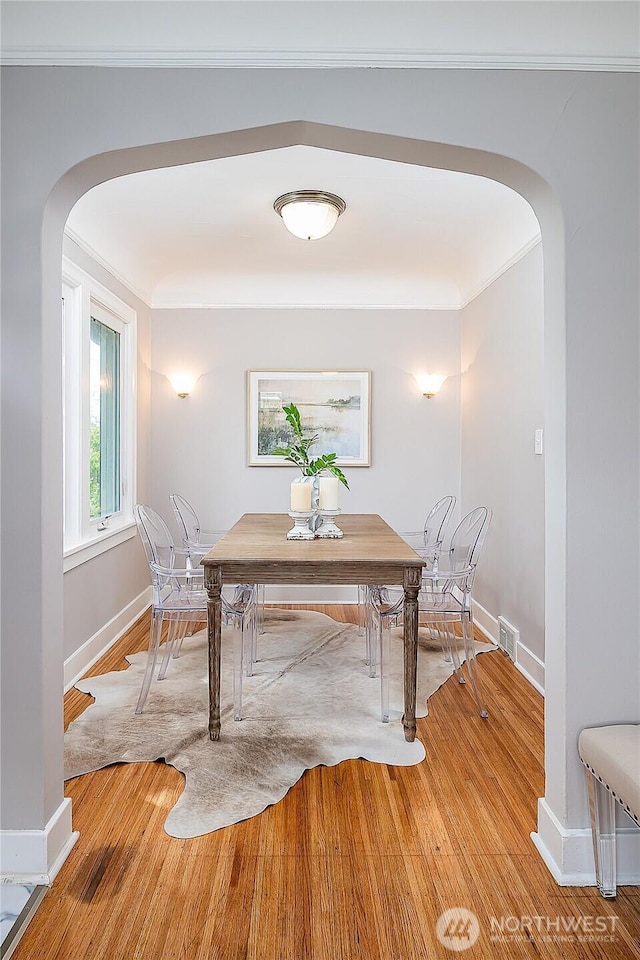 8047 Earl Ave NW, Seattle, WA 98117 - dining room with arched walkways, crown molding, and light wood-style floors