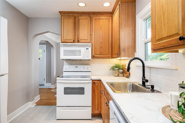 8047 Earl Ave NW, Seattle, WA 98117 - kitchen featuring white appliances, tasteful backsplash, brown cabinetry, healthy amount of natural light, and recessed lighting