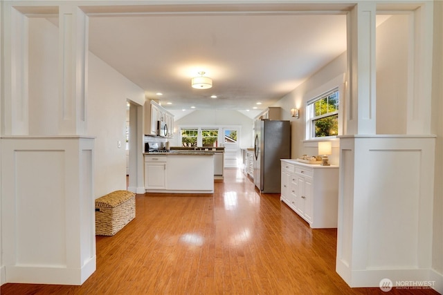 5111 N 39th St, Tacoma, WA 98407 - kitchen with freestanding refrigerator, light wood-style flooring, white cabinetry, and lofted ceiling