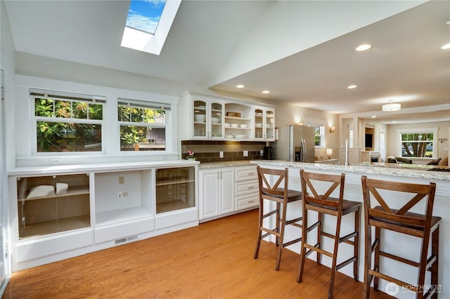 5111 N 39th St, Tacoma, WA 98407 - kitchen with stainless steel fridge with ice dispenser, a kitchen breakfast bar, plenty of natural light, glass insert cabinets, and recessed lighting