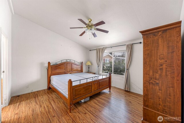 6350 Portal Way Unit 75, Ferndale, WA 98248 - bedroom with wood finished floors, vaulted ceiling, and a ceiling fan