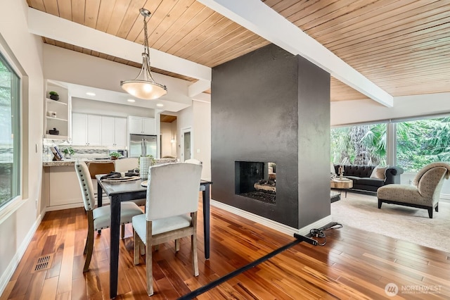 11446 Ohde Ave, Kirkland, WA 98033 - dining space featuring a wooden ceiling with exposed beams, light wood-style floors, and a multi sided fireplace
