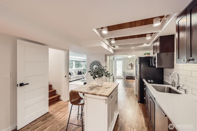 11446 Ohde Ave, Kirkland, WA 98033 - kitchen with wood counters, stainless steel appliances, a breakfast bar, wood finished floors, and backsplash