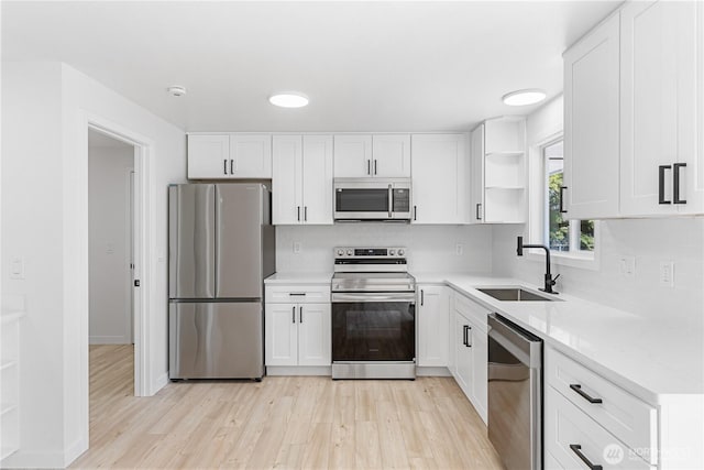 7611 Easy St, Everett, WA 98203 - kitchen with appliances with stainless steel finishes, open shelves, light wood-style flooring, and white cabinetry