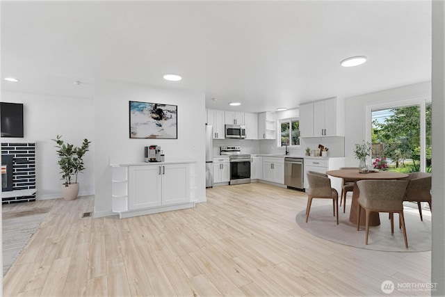 7611 Easy St, Everett, WA 98203 - kitchen with appliances with stainless steel finishes, white cabinets, light wood finished floors, recessed lighting, and light countertops