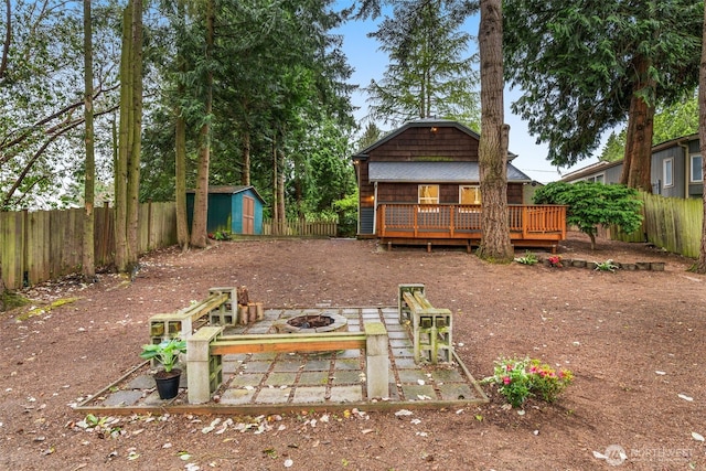 15516 10th Ave NE, Shoreline, WA 98155 - fenced backyard with an outdoor fire pit, a deck, and a storage unit