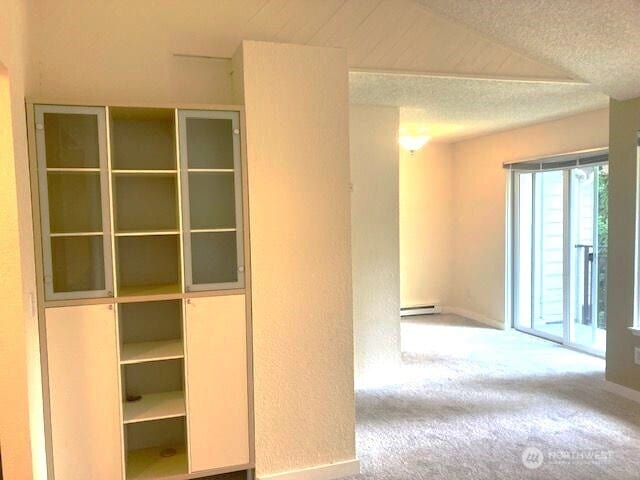 12617 NE 130th Way Unit E303, Kirkland, WA 98034 - hall with carpet flooring, a baseboard heating unit, and a textured ceiling