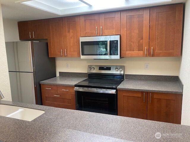 12617 NE 130th Way Unit E303, Kirkland, WA 98034 - kitchen with appliances with stainless steel finishes, brown cabinets, and dark countertops
