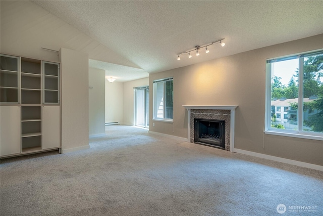 12617 NE 130th Way Unit E303, Kirkland, WA 98034 - unfurnished living room with carpet floors, a fireplace with flush hearth, baseboard heating, and a textured ceiling