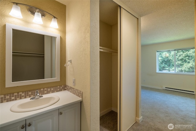 12617 NE 130th Way Unit E303, Kirkland, WA 98034 - bathroom featuring baseboard heating, a textured wall, vanity, a textured ceiling, and decorative backsplash