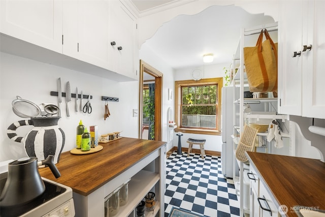 1631 16th Ave Unit 114, Seattle, WA 98122 - kitchen with wood counters, tile patterned floors, white cabinets, and white range with electric cooktop