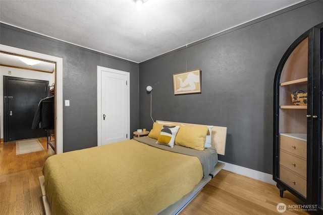 1631 16th Ave Unit 114, Seattle, WA 98122 - bedroom with light wood finished floors, a textured wall, and a closet