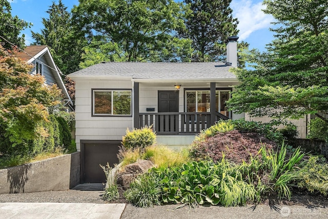 4754 46th Ave NE, Seattle, WA 98105 - view of front of property with an attached garage, a chimney, a porch, driveway, and a shingled roof
