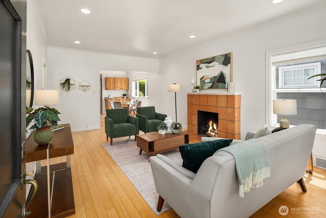 4754 46th Ave NE, Seattle, WA 98105 - living area with light wood finished floors, a fireplace, ornamental molding, and recessed lighting