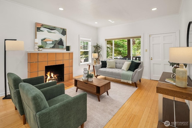 4754 46th Ave NE, Seattle, WA 98105 - living room with light wood-type flooring, a tile fireplace, crown molding, and recessed lighting
