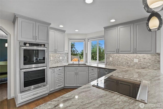 2601 59th St SW, Everett, WA 98203 - kitchen with stainless steel appliances, decorative backsplash, light stone counters, dark wood-style floors, and recessed lighting
