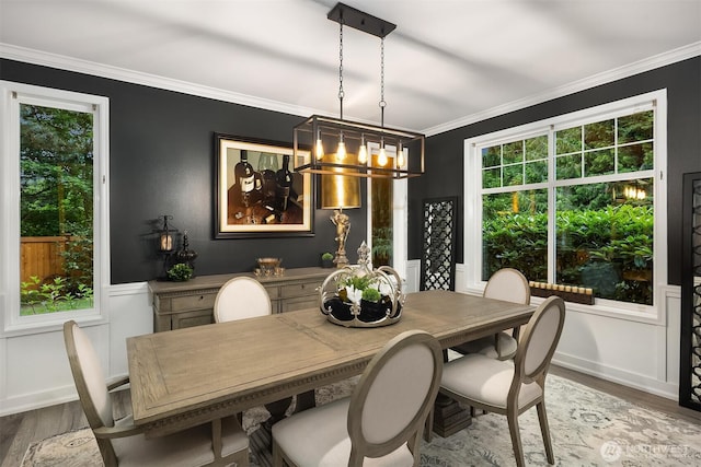 8907 NE 152nd Pl, Bothell, WA 98011 - dining space featuring wood finished floors, healthy amount of natural light, a chandelier, crown molding, and a wainscoted wall