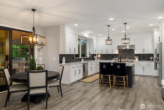 8907 NE 152nd Pl, Bothell, WA 98011 - kitchen featuring dishwasher, under cabinet range hood, light wood finished floors, and recessed lighting