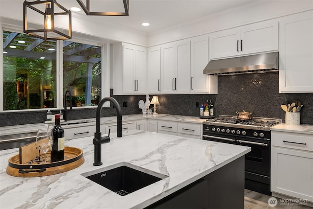 8907 NE 152nd Pl, Bothell, WA 98011 - kitchen with under cabinet range hood, high end range, tasteful backsplash, white cabinetry, and light stone countertops