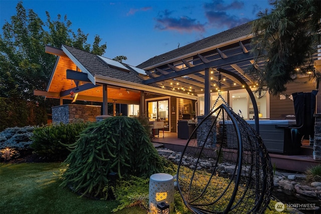 8907 NE 152nd Pl, Bothell, WA 98011 - rear view of property featuring a hot tub, roof mounted solar panels, a ceiling fan, and a deck