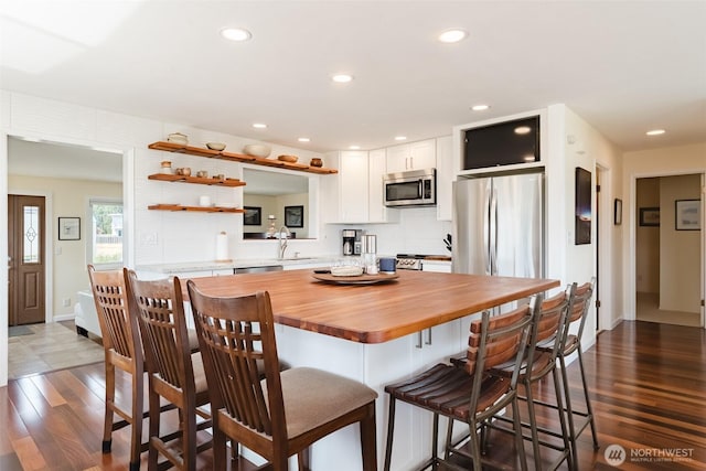 4452 Saltspring Dr, Ferndale, WA 98248 - kitchen featuring appliances with stainless steel finishes, white cabinetry, wooden counters, decorative backsplash, and dark wood finished floors