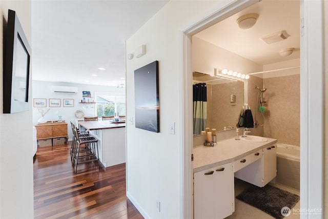 4452 Saltspring Dr, Ferndale, WA 98248 - bathroom with an AC wall unit, wood finished floors, vanity, and shower / bath combination with curtain