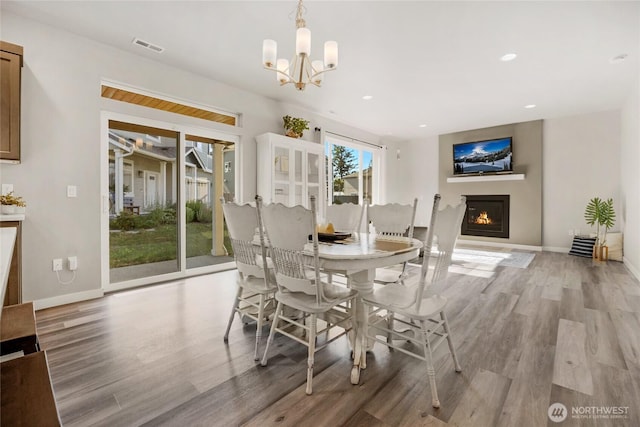 803 Loves Hill Dr, Sultan, WA 98294 - dining space with light wood-style floors, a chandelier, a glass covered fireplace, and recessed lighting