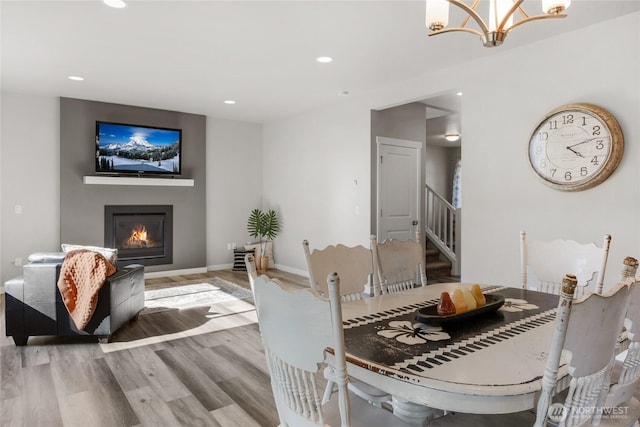803 Loves Hill Dr, Sultan, WA 98294 - dining space featuring stairway, wood finished floors, a glass covered fireplace, recessed lighting, and a chandelier