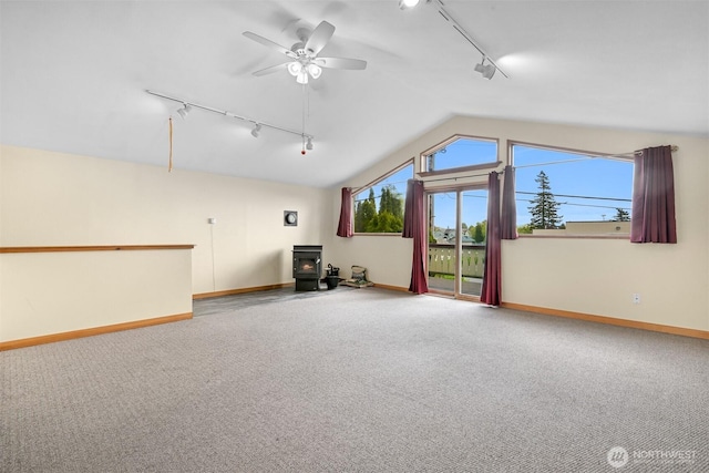 2234 Main St, Ferndale, WA 98248 - unfurnished living room featuring rail lighting, a wood stove, carpet flooring, vaulted ceiling, and a ceiling fan