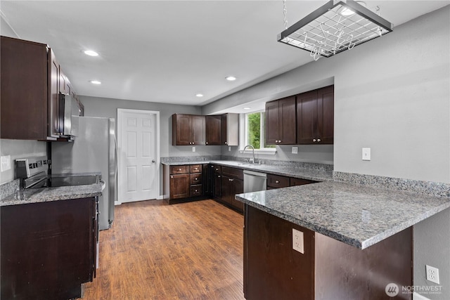 29319 132nd Ave E, Graham, WA 98338 - kitchen featuring a peninsula, appliances with stainless steel finishes, wood finished floors, dark brown cabinetry, and recessed lighting