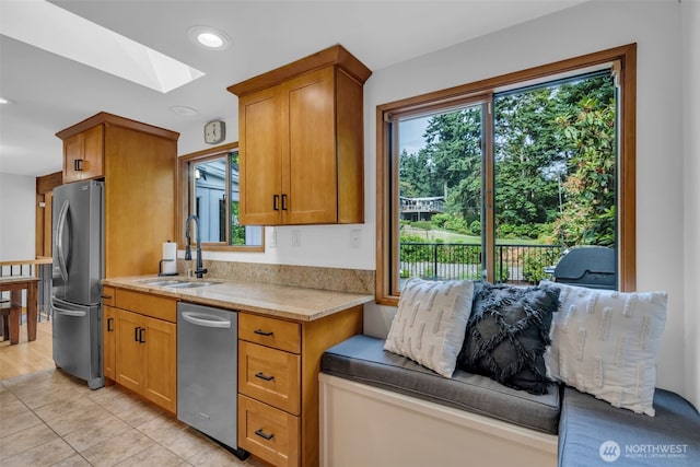 13102 16th Ave SW, Burien, WA 98146 - kitchen featuring appliances with stainless steel finishes, a skylight, brown cabinetry, light tile patterned floors, and recessed lighting