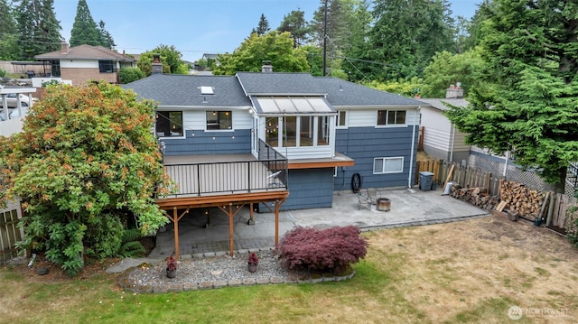13102 16th Ave SW, Burien, WA 98146 - back of property with a patio, a fenced backyard, a wooden deck, a shingled roof, and a chimney