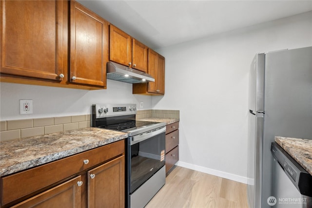 4709 176th St SW Unit C1, Lynnwood, WA 98037 - kitchen with appliances with stainless steel finishes, under cabinet range hood, brown cabinetry, and light wood-style floors
