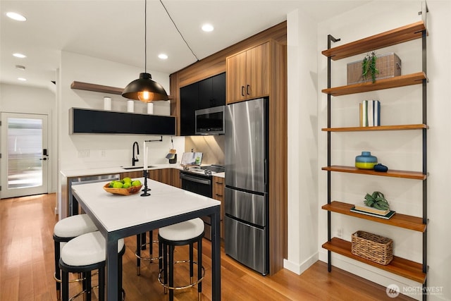3626 1st Ave NW Unit A, Seattle, WA 98107 - kitchen featuring open shelves, appliances with stainless steel finishes, light wood-style flooring, light countertops, and recessed lighting