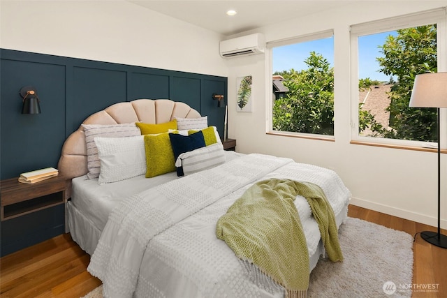 3626 1st Ave NW Unit A, Seattle, WA 98107 - bedroom featuring an AC wall unit, wood finished floors, and recessed lighting