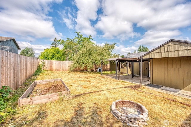 218 125th St S, Tacoma, WA 98444 - fenced backyard featuring a garden, an outdoor fire pit, and a patio