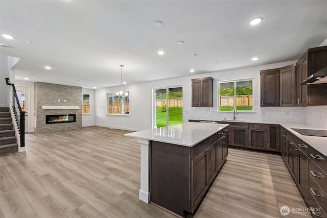 15406 210th Ave E Unit 317, Bonney Lake, WA 98391 - kitchen featuring dark brown cabinets, tasteful backsplash, light countertops, a center island, and black electric stovetop