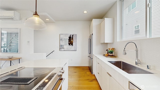 4250 Linden Ave N, Seattle, WA 98103 - kitchen featuring a wall mounted AC, light wood-type flooring, stainless steel refrigerator, range with electric cooktop, and hanging light fixtures