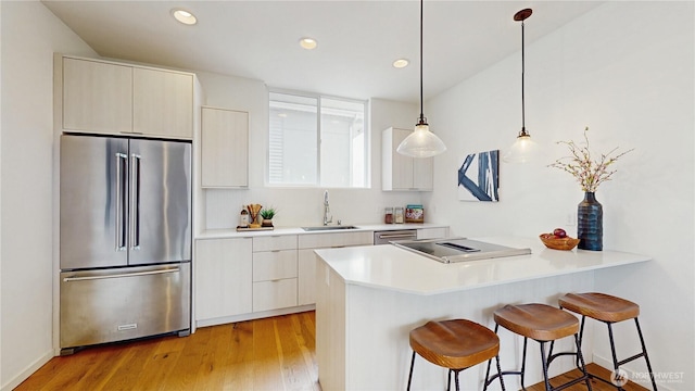 4250 Linden Ave N, Seattle, WA 98103 - kitchen featuring appliances with stainless steel finishes, a breakfast bar area, a peninsula, modern cabinets, and recessed lighting